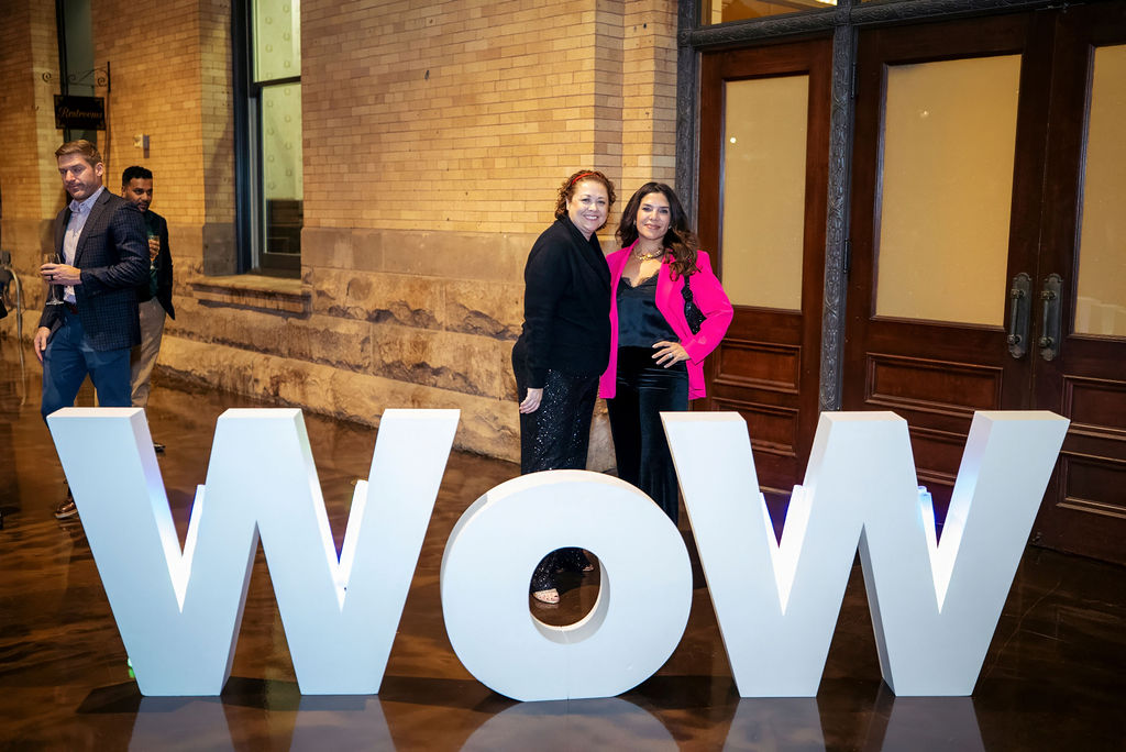 Attendees posing with the WoW letters at the evening reception