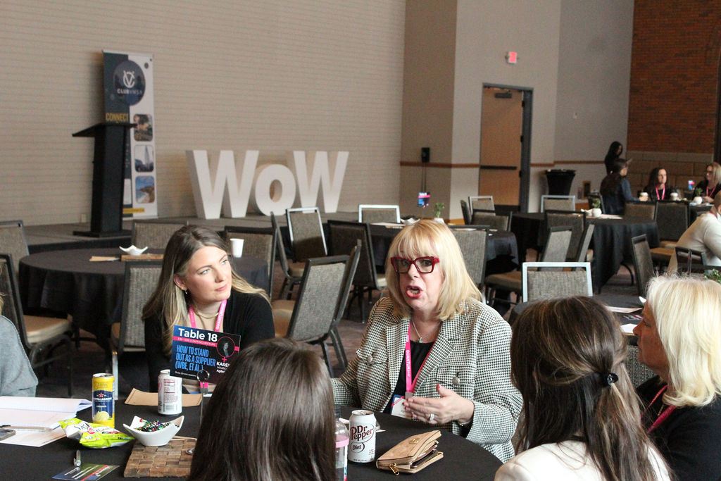 Attendees in conversation at a Women of Work roundtable table