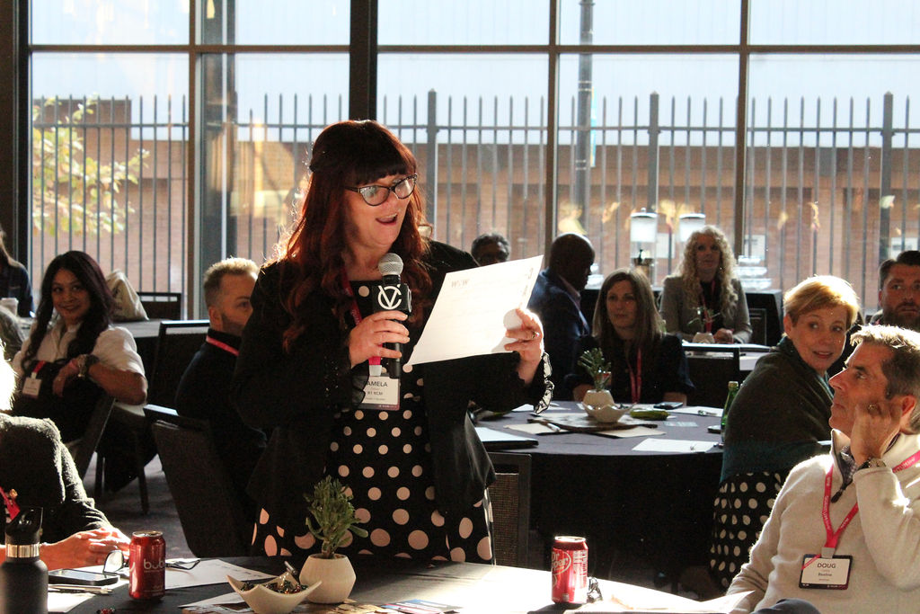 A leader speaking with a microphone during the Women of Work program