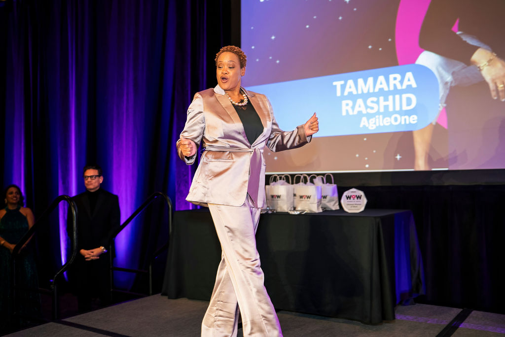 An award recipient celebrating on stage as her name is revealed